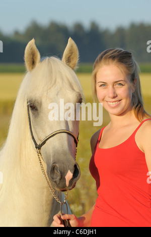 Ragazza e un colorato palomino Paso Fino a cavallo al mattino Foto Stock