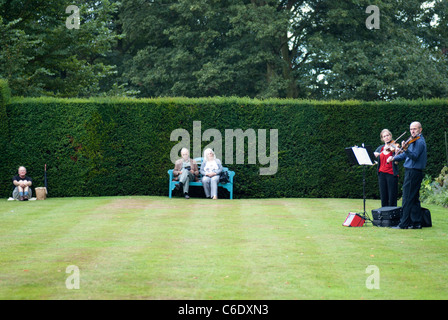 Due violinista intrattenere i visitatori a Renishaw Hall, Derbyshire, Inghilterra, Regno Unito. Foto Stock