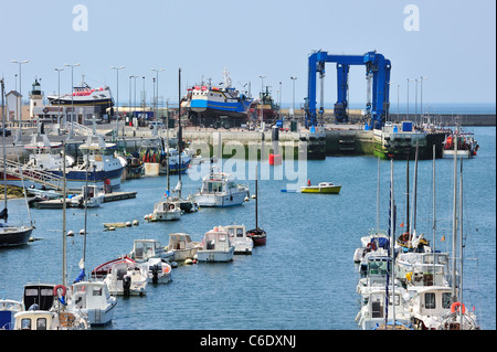 Barche a vela in marina e barche da pesca sul cantiere di costruzione navale per lavori di manutenzione nella porta di Guilvinec, Bretagna Francia Foto Stock
