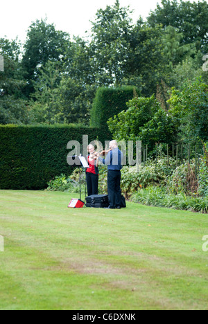 Due violinista intrattenere i visitatori a Renishaw Hall, Derbyshire, Inghilterra, Regno Unito. Foto Stock