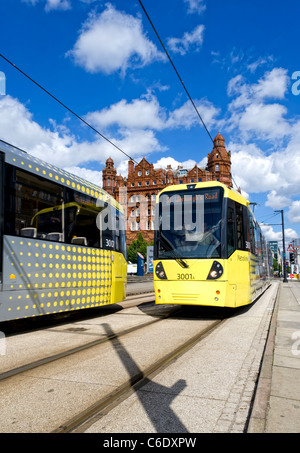 Due moderni giallo Metrolink i tram passano ogni altra tra Deansgate e Piazza San Pietro stazioni nel centro di Manchester Foto Stock