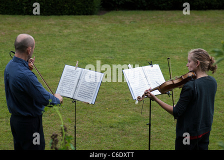 Due violinista intrattenere i visitatori a Renishaw Hall, Derbyshire, Inghilterra, Regno Unito. Foto Stock