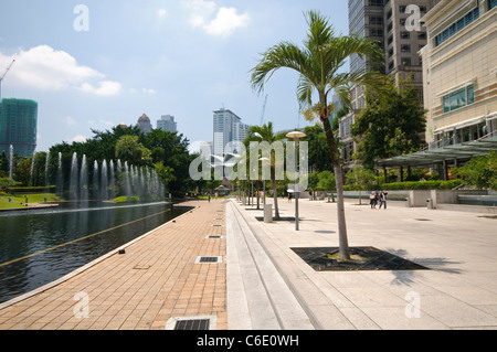 KLCC Park presso le Petronas Twin Towers di fronte alla skyline con edifici di uffici e hotel di Kuala Lumpur, Malesia, Asia Foto Stock
