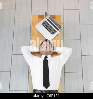 Imprenditore caucasico dormire sul banco di lavoro Foto Stock