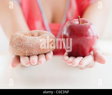 Stati Uniti d'America, New Jersey, Jersey City, Close up della donna e delle sue mani tenendo a ciambella e Apple Foto Stock