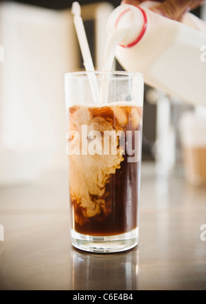 Stati Uniti d'America, New Jersey, Jersey City, stretta di mano versando il latte nel caffè ghiacciato Foto Stock