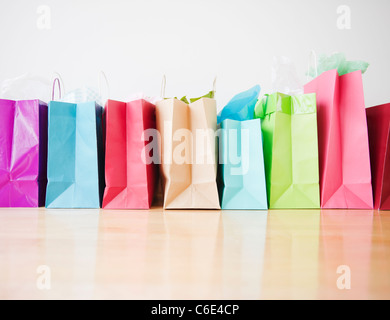 Colorata borse per lo shopping in piedi in fila Foto Stock