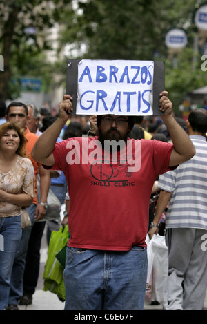 Un uomo detiene un segno offrendo free hugs in Santiago centro citta'. Santiago del Cile, Sud America Foto Stock