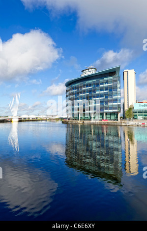 Vista verso uno dei ponti e e Media City da attraverso uno dei docks a Salford Quays vicino a Manchester, Inghilterra Foto Stock