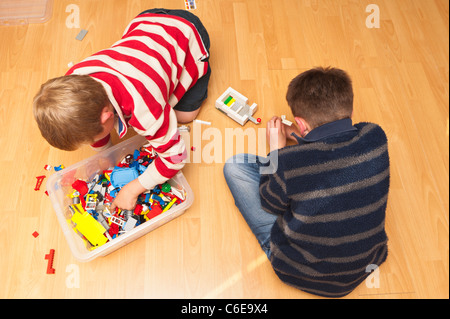 Due ragazzi giocare Lego interni nel Regno Unito Foto Stock