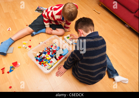 Due ragazzi giocare Lego interni nel Regno Unito Foto Stock