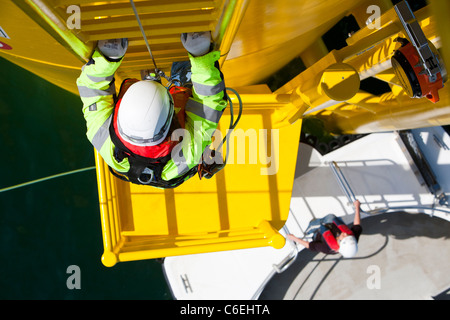 Un ingegnere che si arrampica su un pezzo di transizione di una turbina eolica sulla Walney offshore wind farm Foto Stock