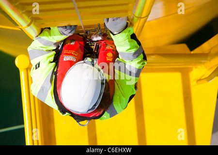 Un ingegnere che si arrampica su un pezzo di transizione di una turbina eolica sulla Walney offshore wind farm Foto Stock