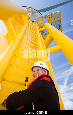 Un operaio si arrampica su una turbina, al Walney offshore wind farm Foto Stock