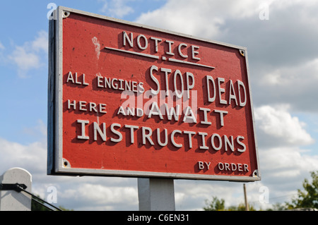 Segno su una linea ferroviaria che istruisce i driver per fermata morti e attendere istruzioni Foto Stock