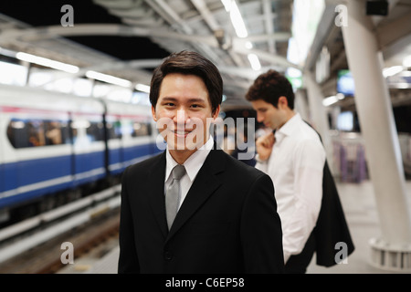 Uomini d'affari in attesa su piattaforma per il treno della metropolitana