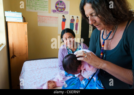 Esteri fornitore di assistenza sanitaria esaminando un bambino Maya durante una clinica gratuita nella regione di Atitlan Guatemala Foto Stock