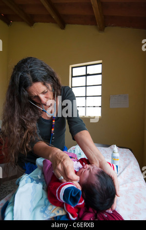 Esteri specialista medico da una ONG guardando un bambino Maya in un libero clinica sanitaria nella regione di Atitlan Guatemala Foto Stock