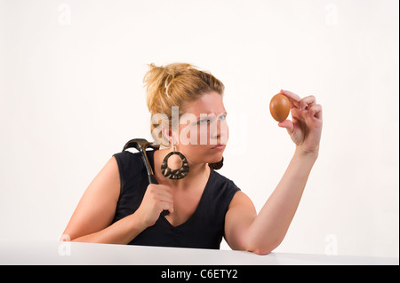 Pianificazione bionda alcuni male con un uovo Foto Stock