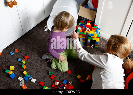 Una giovane madre giocando con Lego con sua figlia Foto Stock