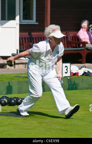 Donna anziana giocando a bocce su prato Foto Stock