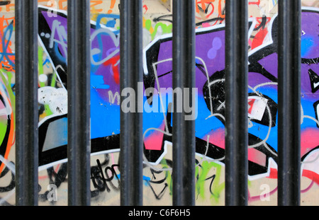 Graffiti dietro le sbarre sulle pareti sotto un cavalcavia316 Hanworth, Surrey, England, Regno Unito Foto Stock