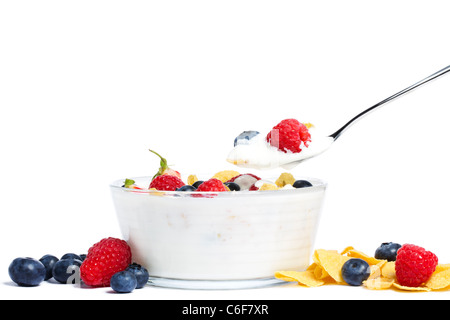 Yogurt con mirtilli, fragole, lamponi e cornflakes su sfondo bianco Foto Stock