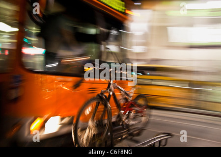Bus di sfocatura di movimento con la bicicletta sulla parte anteriore Foto Stock
