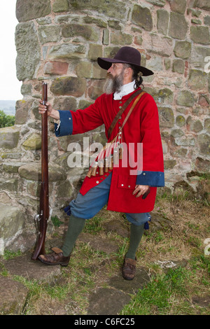 Musketman o Musketeer Fusilier con armi da fuoco di 17th secolo, gruppo di storia vivente che rienacing vita & tempi. L'unità di fanteria variava con costumi storici militari alla rievocazione della guerra. Dragoon a Tutbury Castle, Derbyshire, Regno Unito Foto Stock