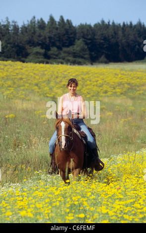 Donna - equitazione sulla Quarter Horse un prato Foto Stock