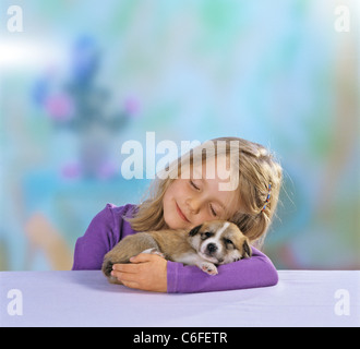 La ragazza con la metà di razza cucciolo di cane ( 21 giorni ) nel braccio Foto Stock