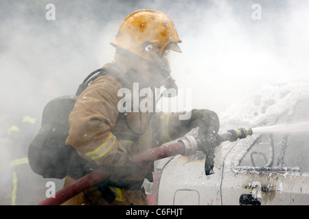 Firefighter utilizza CAFS per estinguere un incendio auto. Foto Stock