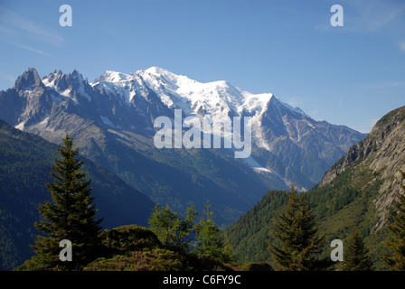 Il picco coperto di neve di Mont Blanc sorge sopra le montagne circostanti visto da una valle in Francia Foto Stock