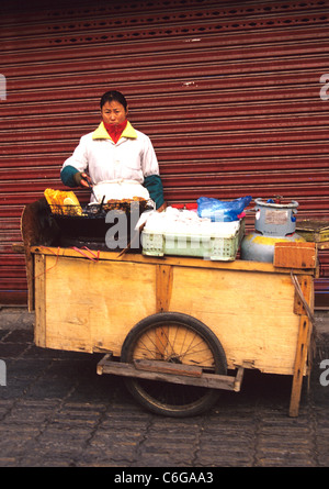 Donna cuochi e vende pasta dalla cucina casalinga carrello su una strada a Shanghai Foto Stock