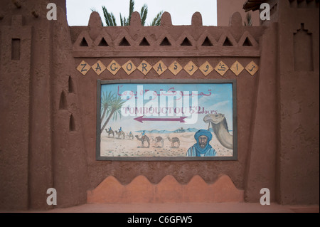 Cartello stradale per Tombouctou '52 giorni da camel' sul bordo del villaggio di Zagora, sud del Marocco Foto Stock