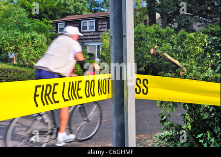 Uomo passato ciclistica tree uragano Irene soffiava giù sulla strada, carrello il giorno prima. Nastro giallo 'NON CROSS', New York 2011-08-29 Foto Stock