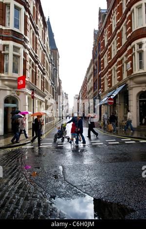 Un estate doccia a pioggia cade sul shopper in Covent Garden di Londra. Foto Stock