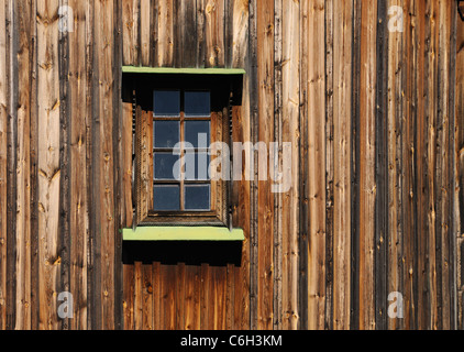 Il vecchio edificio in legno in prossimità di una parete con una finestra Foto Stock