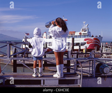 I bambini utilizzando il telescopio di vedetta, Pier 39, Fisherman's Wharf di San Francisco, California, Stati Uniti d'America Foto Stock