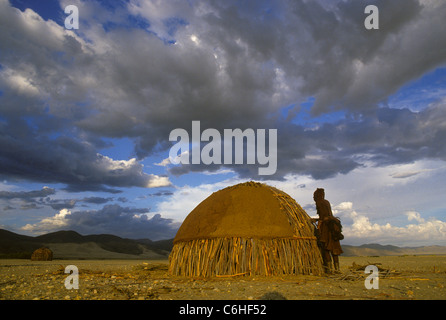 Donna Himba costruzione di un tradizionale rifugio di alveare Foto Stock