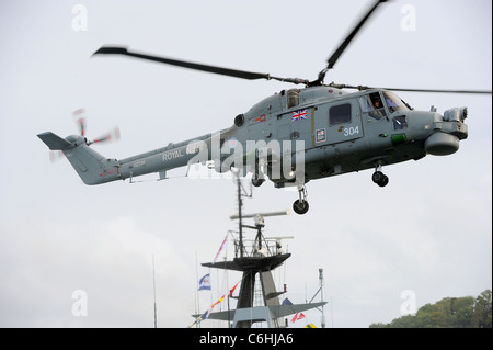 La Royal Navy Lynx di manovra in elicottero nel cielo sopra il fiume Dart in Dartmouth durante il Dartmouth Royal Regata Foto Stock