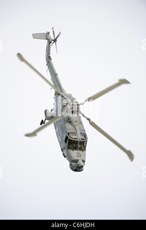 La Royal Navy Lynx di manovra in elicottero nel cielo sopra il fiume Dart in Dartmouth durante il Dartmouth Royal Regata Foto Stock