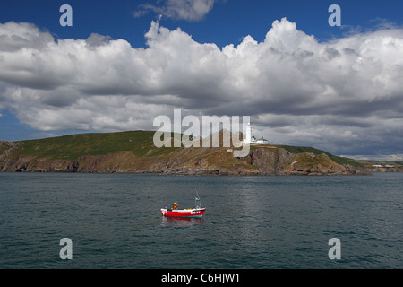 Una piccola barca da pesca che sono ancorate al largo di punto di partenza faro sulla costa del South Devon, Inghilterra, Regno Unito Foto Stock