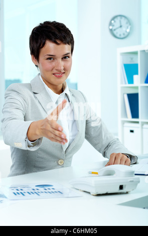 Ritratto di pretty datore di lavoro al lavoro dando la mano per stretta di mano Foto Stock
