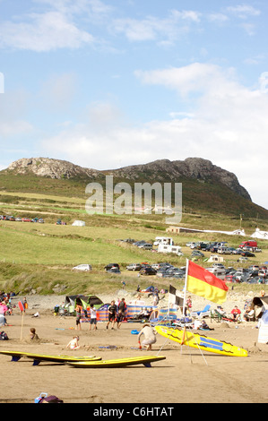 Bagnino bandiera e tavole da surf su Whitesands Bay di St David's, Galles Foto Stock