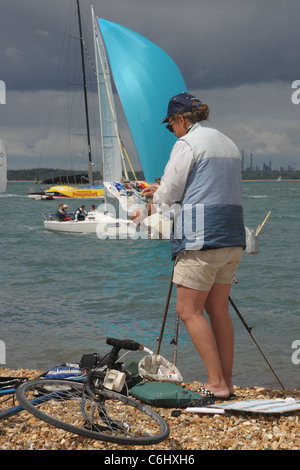 Artista Hilary Thorpe al lavoro dal bordo dell'acqua durante la Cowes Week eventi in barca a vela Foto Stock