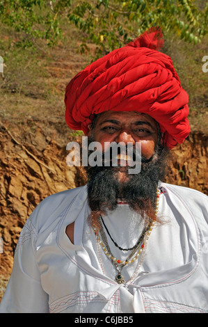 Ritratto di uomo barbuto indossando Turbante Rosso Colli Aravalli Rajasthan in India Foto Stock