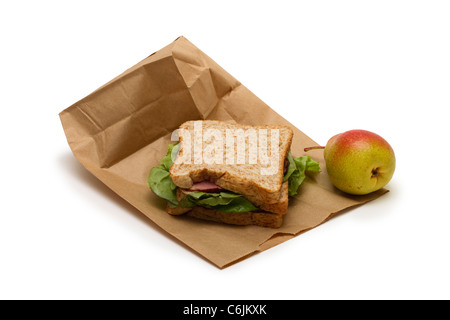 Pranzo al sacco con prosciutto sandwich e una pera su sfondo bianco Foto Stock