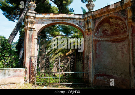 L'elegante sbiadito ingresso ad arco in un diciassettesimo secolo arcade arboree nel parco della Villa Durazzo, Santa Margherita Foto Stock