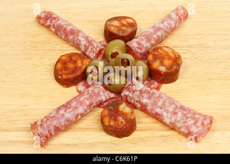Salame chorizo salsicce e olive su una tavola di legno Foto Stock